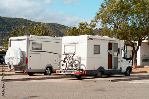 Two car trailers at home on codes with a bicycle attached, parked in the parking lot, technologies