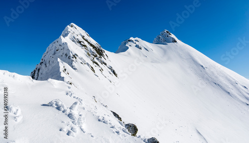 A winter ridge leading to a difficult mountain hiking trail. Tatra Mountains, Poland.