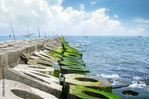 The breakwater covered with green moss stretches out to the sea in Tam Giang Lagoon  Vietnam