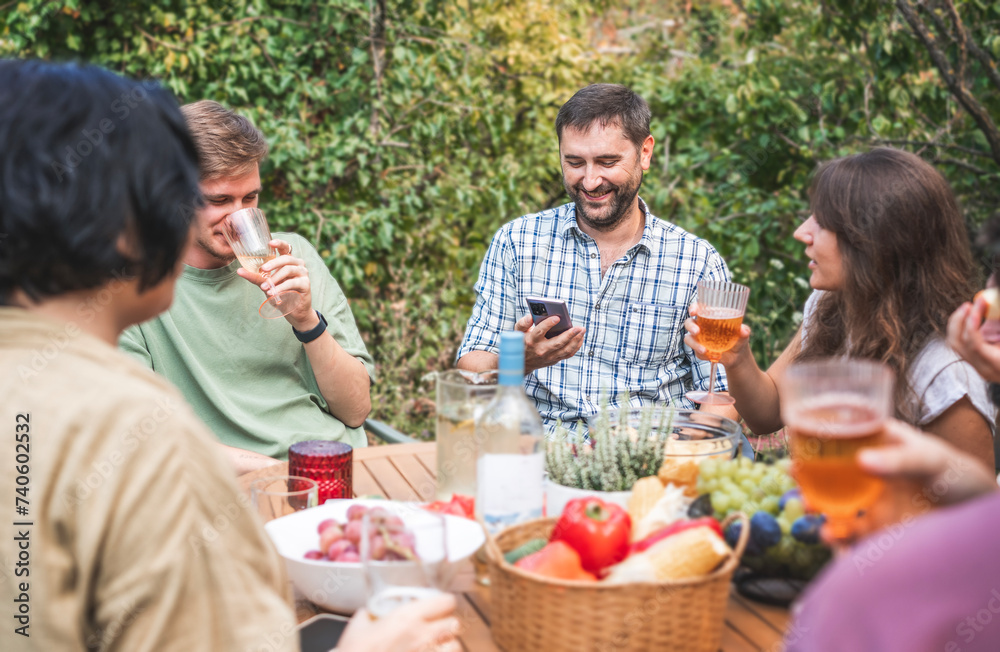 Group of happy young adults having fun at a barbecue party in the garden. Celebration, summer weekend and friendship concept