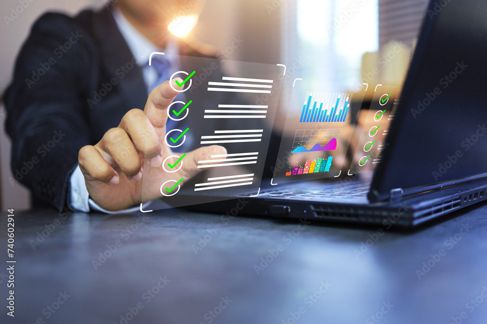 Businessman ticks check mark on laptop computer screen to check ...