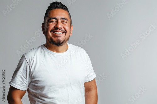 Confident Man Smiling in White T-Shirt Against Neutral Background: A Portrait of Positivity and Assurance