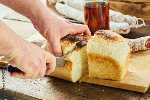 Slicing fresh bread for making sandwiches. The process of making food