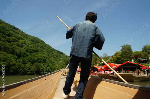 Canvas Print A boatman is punting a river in the Arashiyama area in Kyoto, Japan