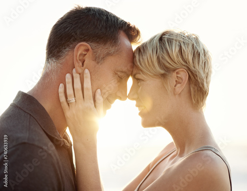 Man, woman and love embrace at sunset for outdoor beach holiday or honeymoon connection, summer or vacation. Couple, happy and California together for sea relax or paradise, relationship or marriage