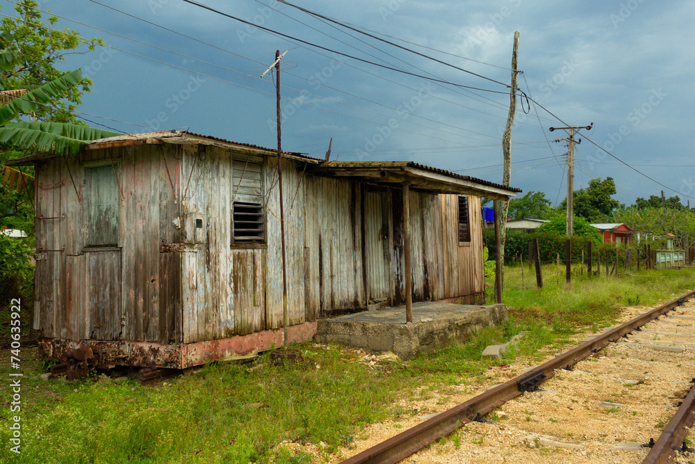 Photograph of a railway hut adapted as accommodation next to some old train tracks.