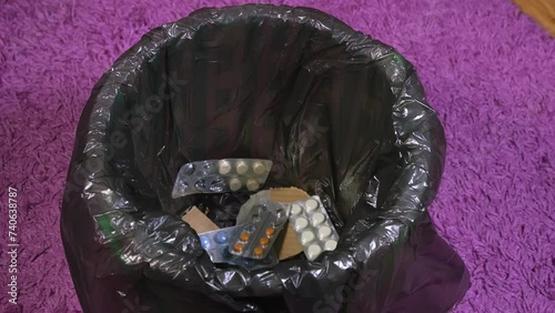 they throw a bunch of different pills into the trash, get rid of medications, medications are no longer needed, packs of antibiotics are thrown away, pills are thrown away