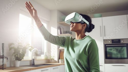 young black woman wearing augmented virtual reality glasses gesturing with her hands while standing in a modern white kitchen.