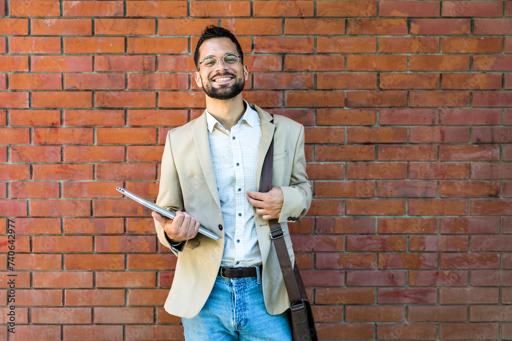 Portrait of young business man outside office building in the alley with brick wall background standing and thinking of solving the problem. Businessperson planning alone without loud employees