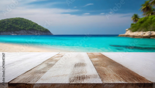 Wooden deck or table overlooking a serene tropical white sandy beach, clear turquoise ocean, and lush green island
