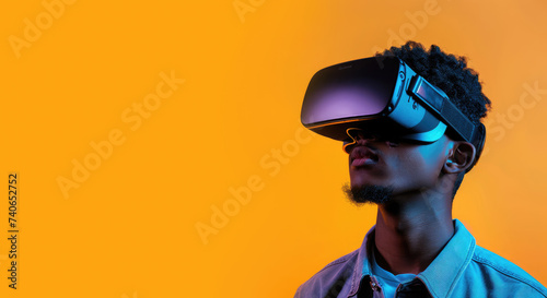 A young man wearing virtual reality headset glasses on a solid orange background. Concept of technology, augmented reality, science, engineering. Copy space for text, advertising, message, logo 