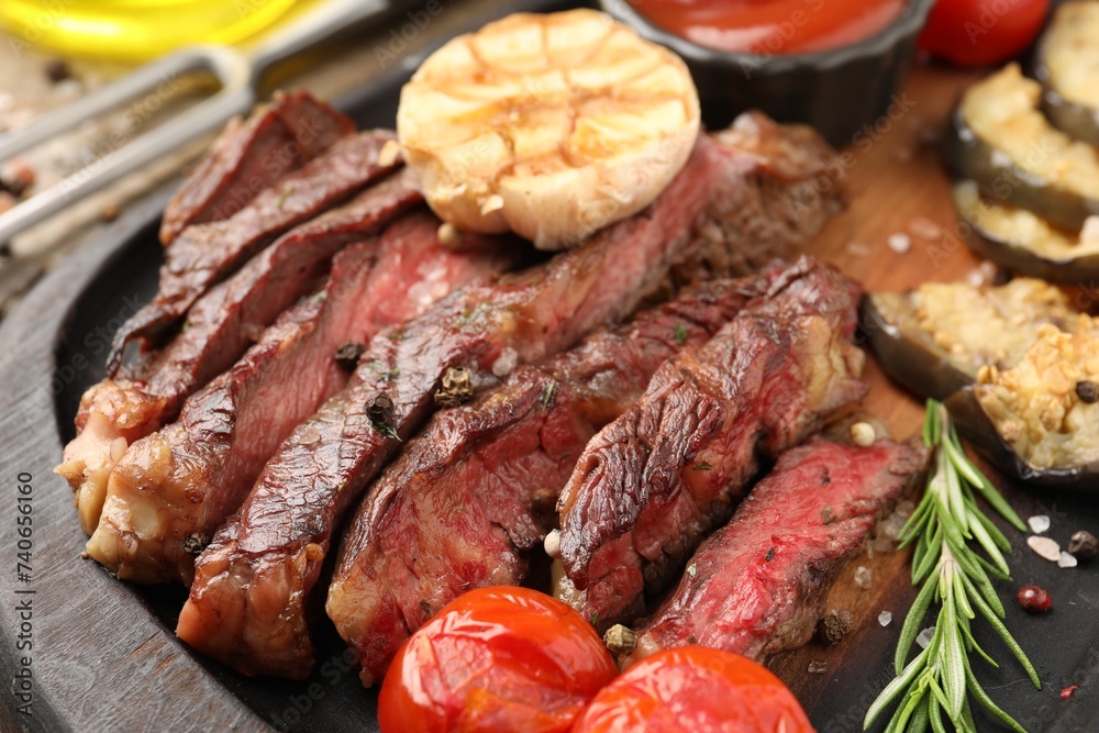 Delicious grilled beef steak with vegetables and spices on table, closeup