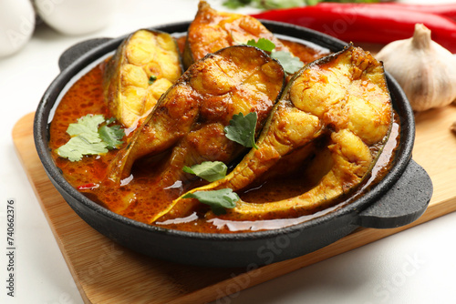 Tasty fish curry on white table, closeup. Indian cuisine