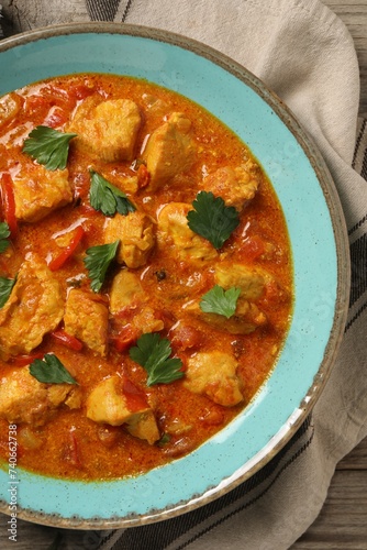 Delicious chicken curry on wooden table, top view