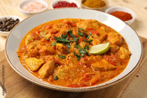 Delicious chicken curry and spices on table, closeup