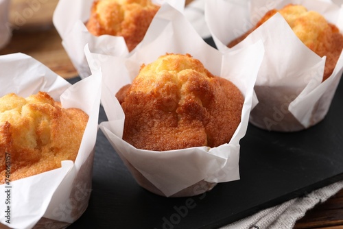 Delicious sweet muffins on wooden table, closeup