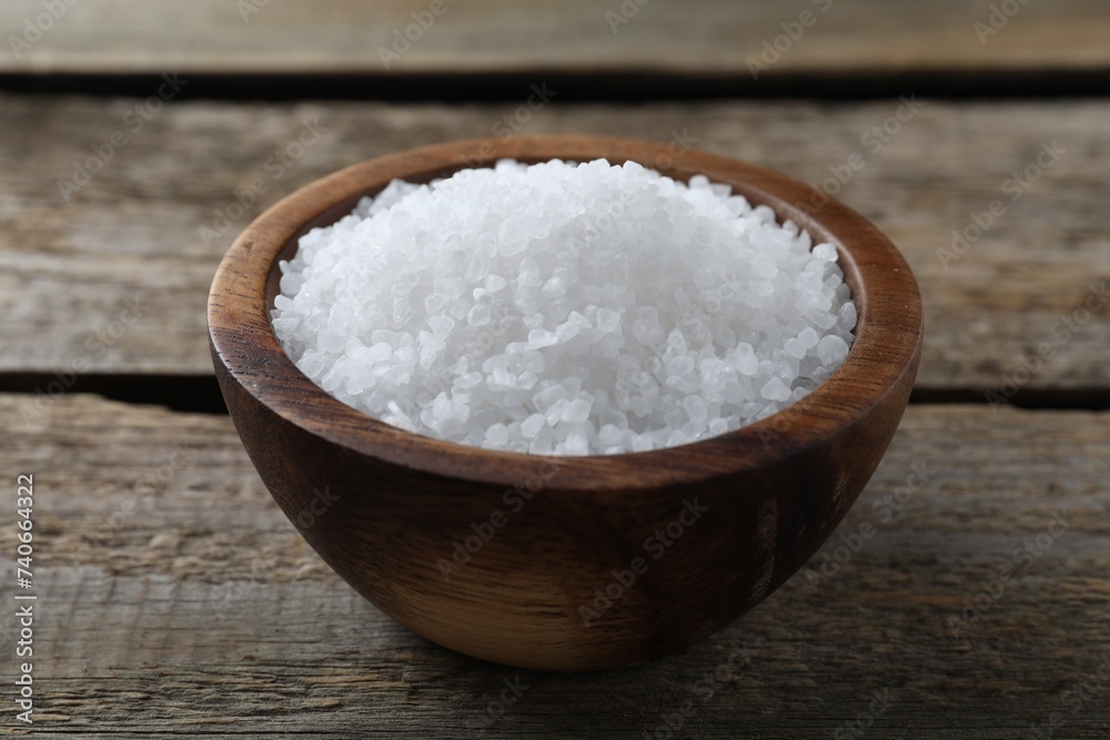 Organic salt in bowl on wooden table, closeup Organic salt in bowl on wooden table, closeup