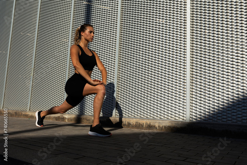 Beautiful woman stretcing outside before morning jogging. Healthy lifestyle. photo