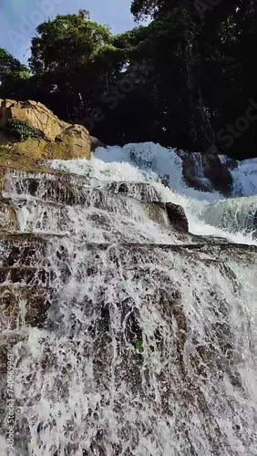 Layered rocks with water stream and splash. Tinuy-an Falls in Bislig, Surigao del Sur. Philippines. Vertical view. photo