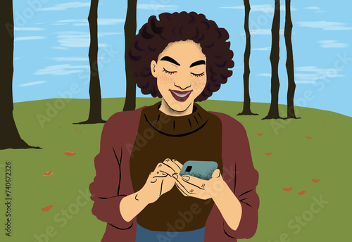 Smiling woman using smartphone in autumn park photo