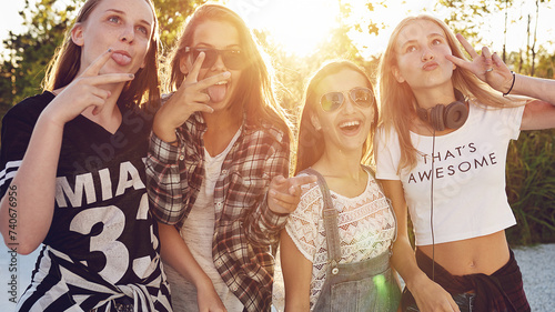 Group of teenagers having fun and makes peace signs and funny faces for the camera