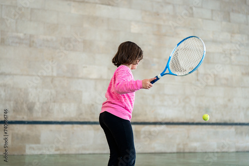 Anonymous young girl playing tennis during sport weekend photo
