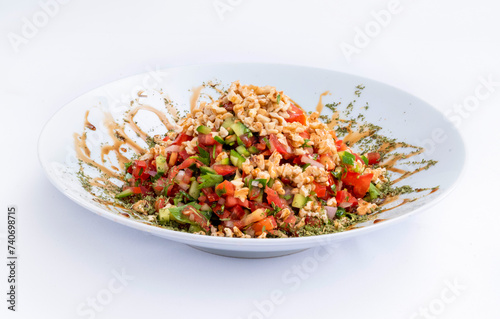 Gavurdagi salad with walnut isolated on white background. Traditional Turkish cuisine salad prepared with tomato, pepper, cucumber, onion, pomegranate syrup, olive oil and walnut.