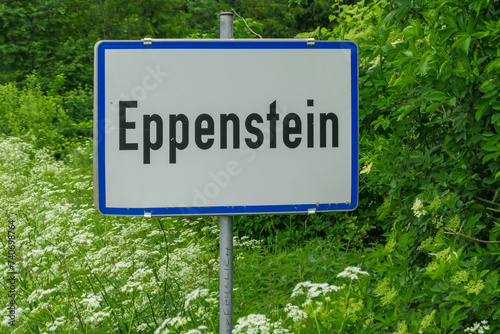 Information sign of entrance of village of Eppenstein in Mur Valley, Lavanttal Alps, Styria, Austria. Signpost is mounted on post and is surrounded by trees and greenery. Tourism. Driving along road