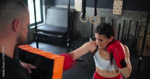 Sports, exercise or boxing with woman and coach at gym for training, practice or spar in preparation for fight. Fitness, health or workout with boxer and personal trainer together for self defense