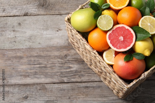 Different cut and whole citrus fruits on wooden table  above view. Space for text