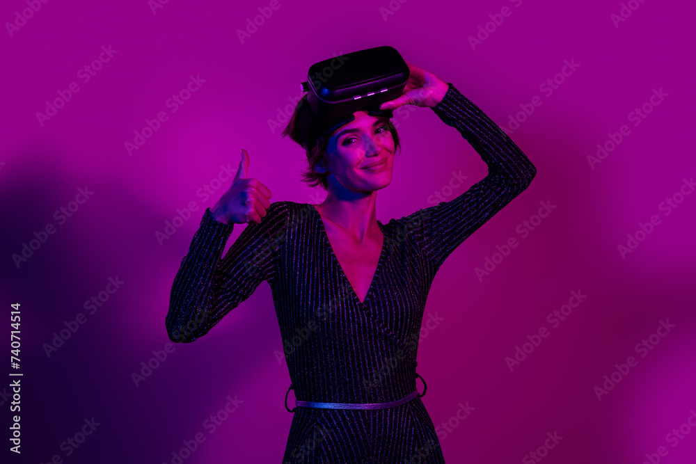 Photo portrait of pretty young girl take off headset gamer thumb up wear trendy overall outfit isolated on neon light pink color background Photo portrait of pretty young girl take off headset gamer thumb up wear trendy overall outfit isolated on neon light pink color background