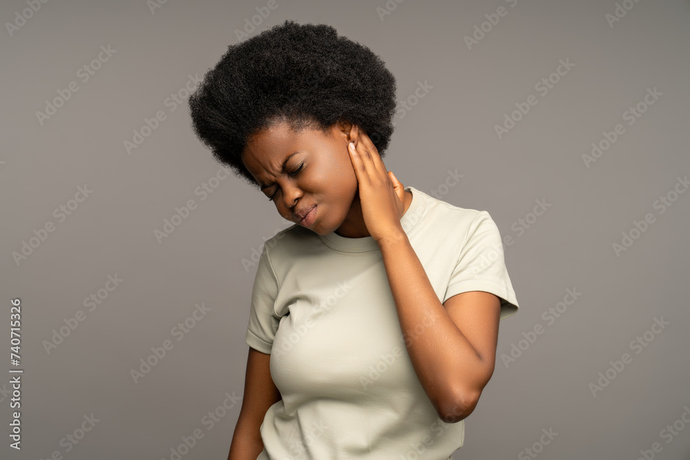 Frowning african american woman, suffering from otitis, having terrible earache, hearing unpleasant sound, touching painful ear in need of otolaryngologist treatment, antiinflammatory medical therapy