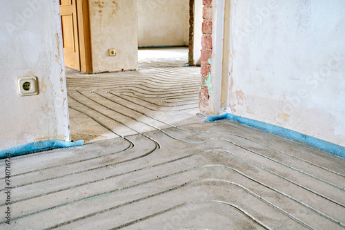 Fußbodenheizung wird in Estrich eingefräst bei einer Renovierung von Einfamilienhaus.  © zenturio1st
