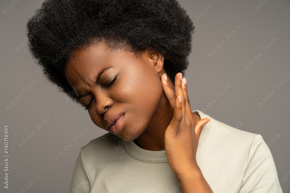 African american woman touching enlarged lymph nodes under ear on neck