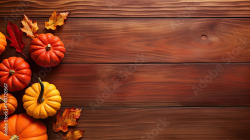 A group of pumpkins with dried autumn leaves and twigs, on a vivid red color wood boards