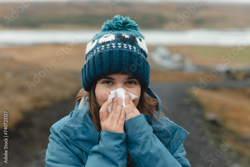 Cold weather woes: woman blows nose in Iceland