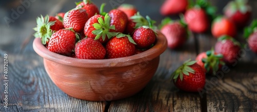 Fresh and juicy strawberries in a rustic bowl on a wooden table