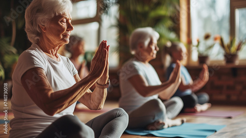 Older women practice yoga, meditate in yoga classes and lead an active and healthy lifestyle. Retirement hobbies and leisure activities for the elderly. Bokeh in the background. 