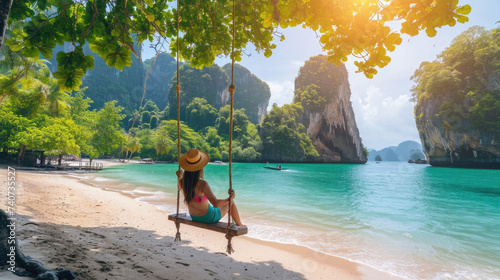 Woman sitting on a swing on a tropical beach in Krabi, Thailand photo