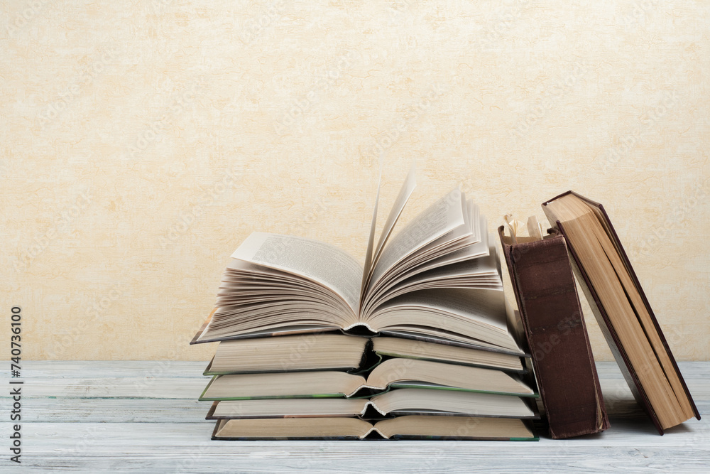 Naklejka premium Open book, hardback colorful books on wooden table. Back to school. Copy space for text. Education business concept.