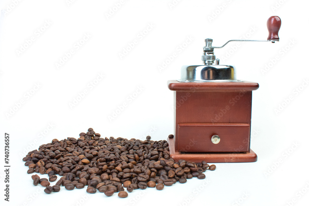 A pile of coffee beans on a white background and a coffee grinder. Top view.