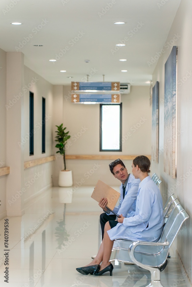 White male and female doctors taking a break sitting and talking to each other White male and female doctors taking a break sitting and talking to each other