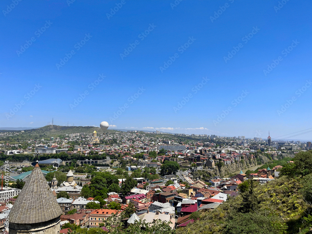 Beautiful landscape panorama of city Tbilisi with hot air balloon on the background of sky