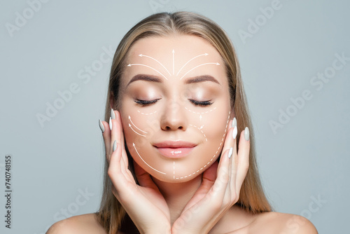 Charming woman with massage or surgery lines on her face. Medicine, cosmetology and facial treatment concept photo