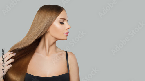 Nice glamorous woman fashion model with long straight healthy hair and makeup posing on white background