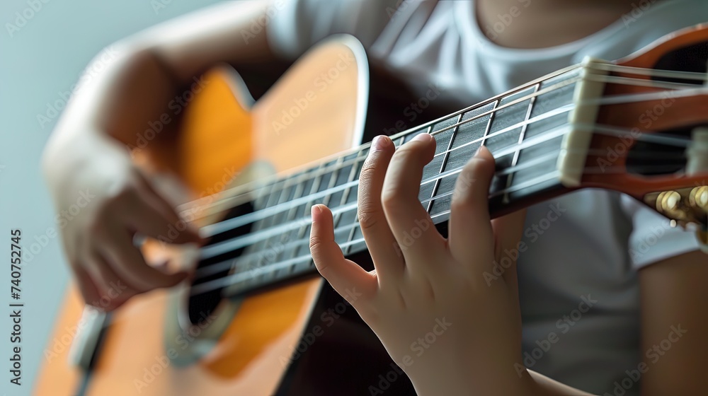 Close up of a child's hands playing the guitar