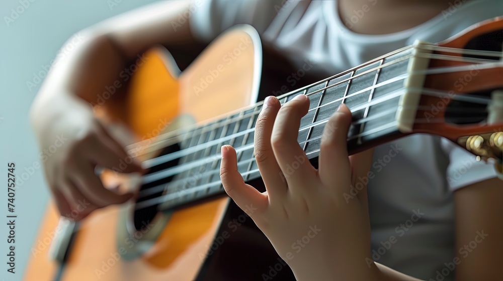 Fototapeta premium Close up of a child's hands playing the guitar