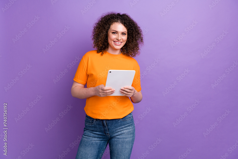 Photo of pretty cute lady dressed orange t-shirt communicating modern gadget empty space isolated violet color background Photo of pretty cute lady dressed orange t-shirt communicating modern gadget empty space isolated violet color background