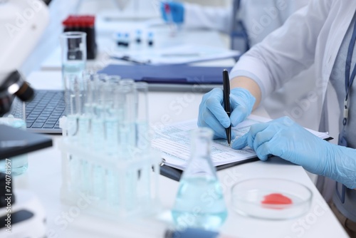 Laboratory worker working at white table  closeup