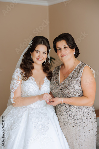 A beautiful and happy mother and her daughter  the bride  are standing next to each other. The best day for parents. Tender moments at the wedding.